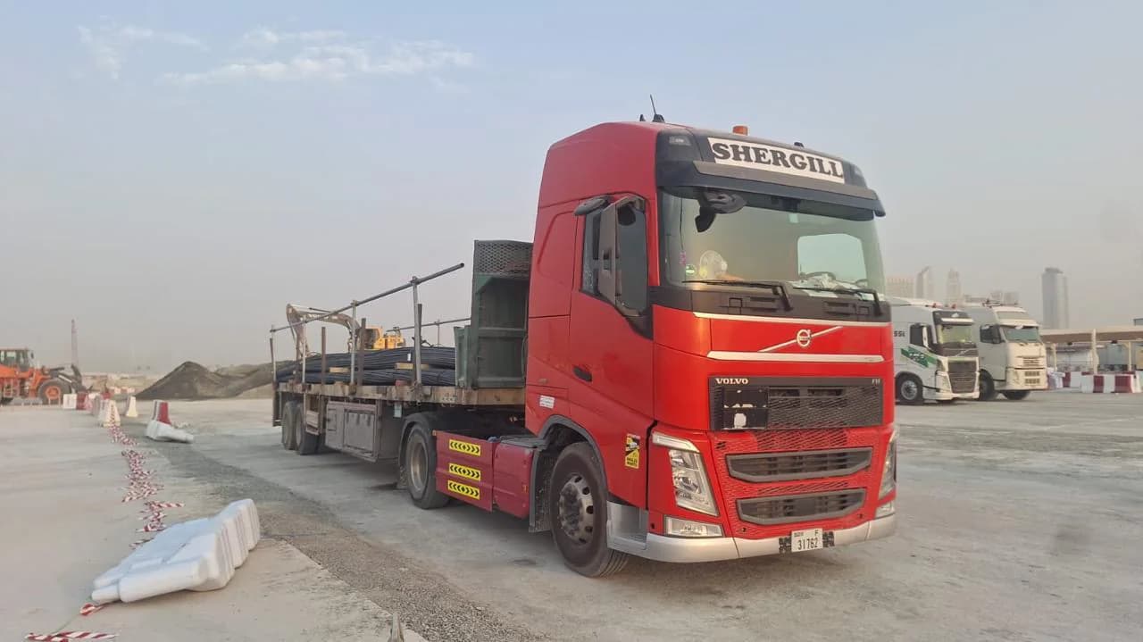Red Shergill Volvo FH prime mover with flatbed trailer in Dubai