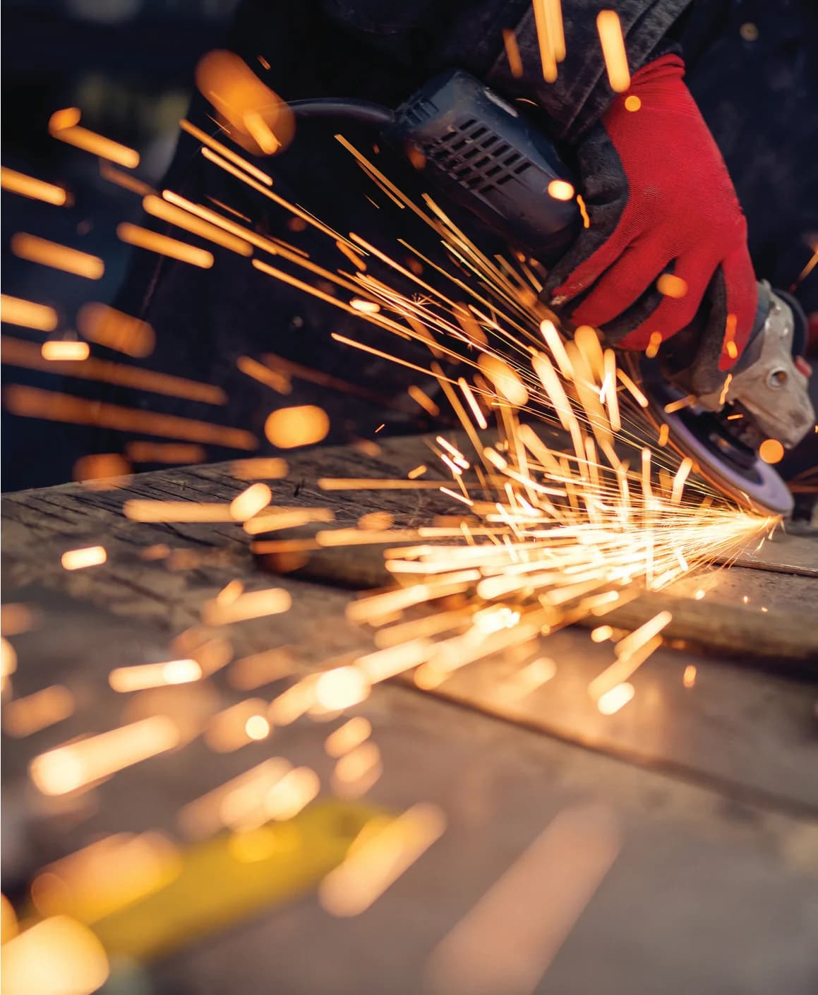 Worker grinding steel with sparks on a construction site
